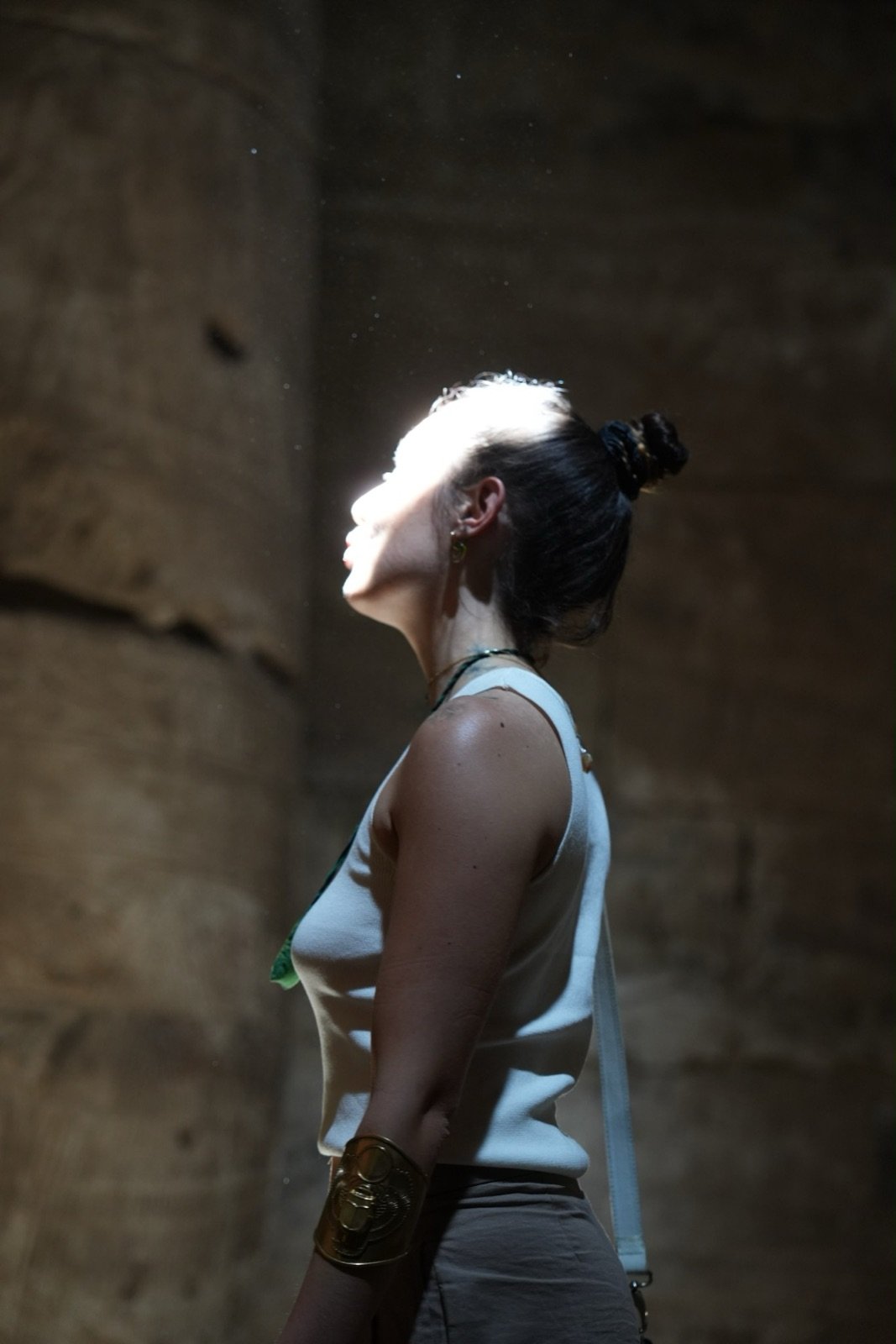 Oriana en un templo, con el rostro iluminado por un haz de luz